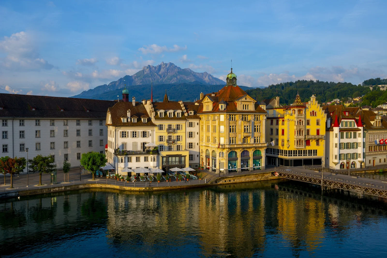 colorful-buildings-near-river-surrounded-by-mountains-lucerne-switzerland-scaled